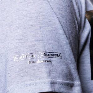 Close-up of a light heather gray t-shirt featuring a distressed black and white 'Remembering Columbia' graphic on the right sleeve