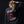 A woman viewed from behind wearing a dark charcoal gray sweatshirt with a large graphic print on the back. The graphic features the words 'FIGHT RAIDERS FIGHT' and an archival image of the Masked Rider