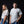 A man and a woman wearing matching white Texas Tech t-shirts with red text on the left chest, posed against a dark studio background.
