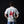 A man viewed from behind wearing a light gray t-shirt with a large red graphic of a rider on a horse and the text 'NOTHING PLAIN ABOUT IT' printed on the back, set against a dark background.